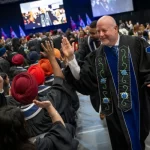President Sean Kennedy high-fives graduates as convocation concludes.