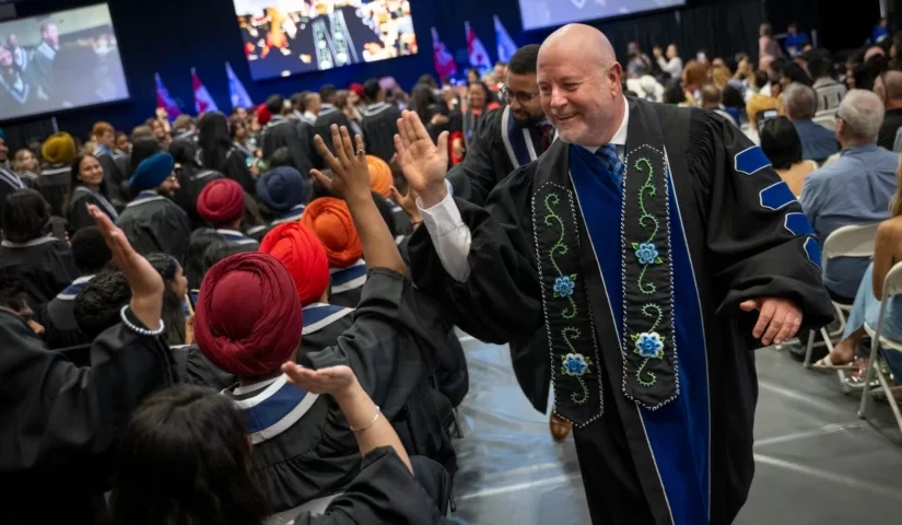 President Sean Kennedy high-fives graduates as convocation concludes.